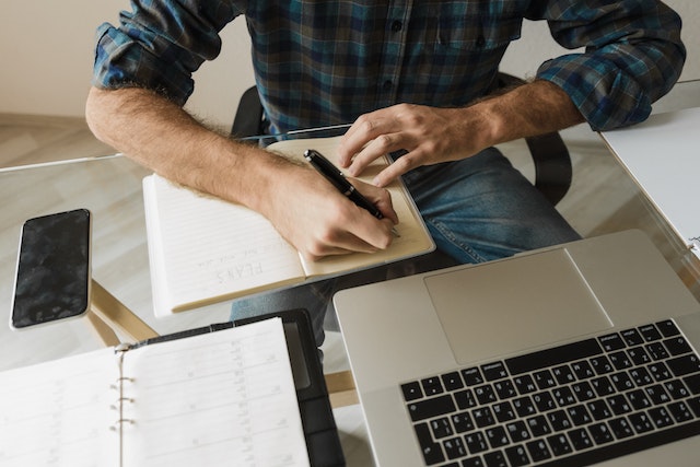 man writing notepad